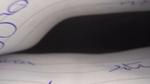 Inside white Paper sheets in book with blue inkt slide out macro closeup Stock Footage 124018026