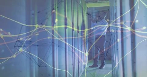 Inspecting admin adjusting server connections in data center corridor, with L Stock Photos