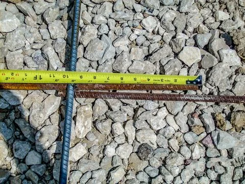 Inspecting and documenting the rebar overlap with a measuring tape at a Stock Photos