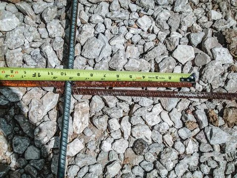 Inspecting and documenting the rebar overlap with a measuring tape at a Stock Photos