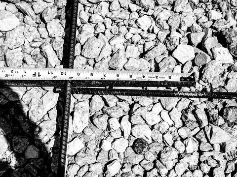 Inspecting and documenting the rebar overlap with a measuring tape at a Stock Photos