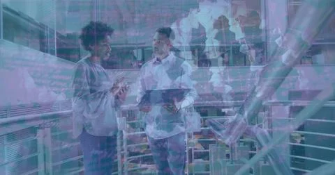 Inspecting code on smartphone and tablet by two engineers near robotic arms on Stock Photos