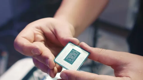 Inspecting the CPU before installation during computer build Stock Footage 328986427