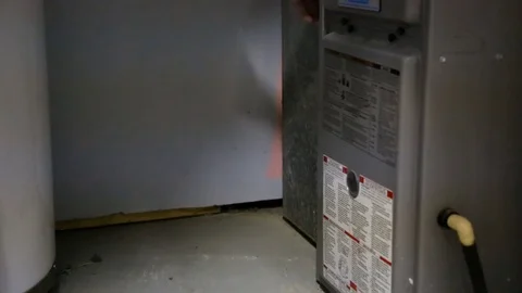 Inspecting furnace filter in basement Stock Footage 77273511