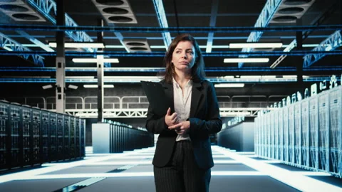 Inspecting hardware, blue wireframe mesh rackmounts and manager in data center Stock Footage 329324768