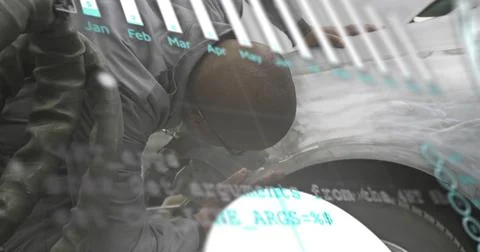 Inspecting mechanic in dark gray coverall safety glasses leaning over tire rim Photos