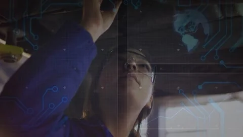 Inspecting technician adjusting overhead part in bay, wearing safety specs and Stock Footage 331757327