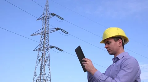 Inspection engineer verifying voltage of electricity poll using tablet, helmet Stock Footage 58514319