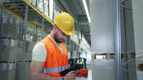 Inspection in progress: warehouse worker with laser scanner. 库存影片 307996662