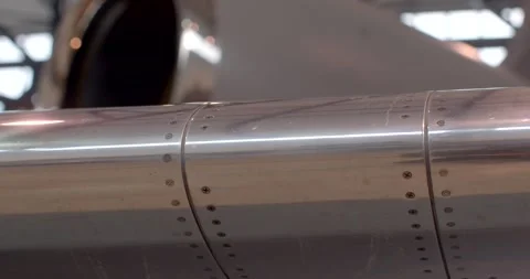 Inspection of rivet lines on jet wing panels near engine cowling surface Stock Footage 333890350