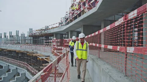Inspector and taskmaster walk along tribune of sports arena Stock Footage 232460655
