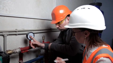 The inspector and the worker check the heating system. Beautiful woman engineer 스톡 동영상 103488972