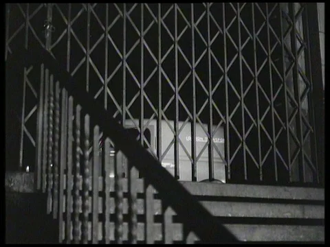 Inspector arrives at entrance to London Underground at night, UK 1958 Video stock 136677458