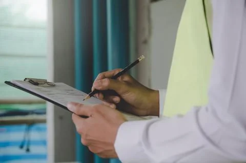Inspector checking and inspecting with clipboard at construction site building  Stock Photos