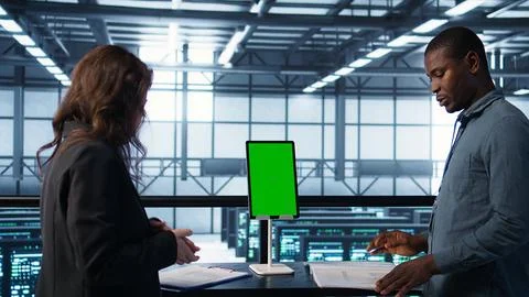 Inspector checking documents in server hub and using greens screen tablet Foto stock