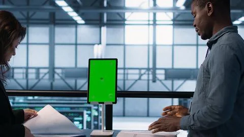 Inspector checking documents in server hub and using greens screen tablet Foto stock
