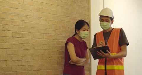 Inspector checking list on work and talk with owner, wearing mask Stock Footage 133905889