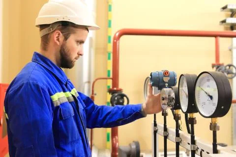 Inspector checking pressure gauges on heating boiler system Stock Photos