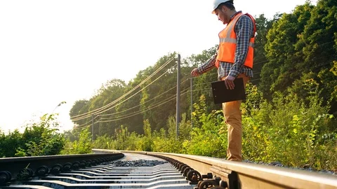 Inspector (Engineer) checking railway or track in the forest. RAW video record. Stockbeeldmateriaal 98456406