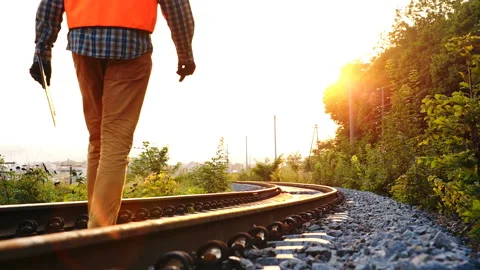 Inspector (engineer) goes on a railway track in the forest to check the railway Stockbeeldmateriaal 107317498