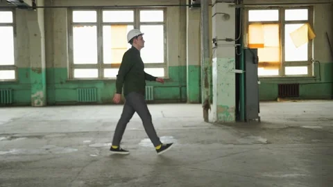 Inspector in helmet walks along the corridor of an old building, looks around Stock Footage 152679855