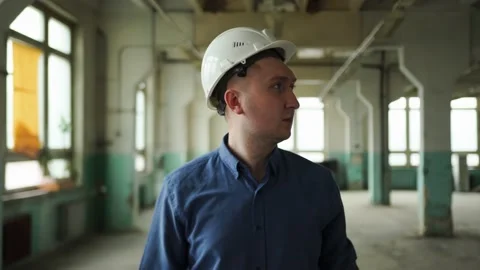 Inspector in helmet walks along the corridor of an old building, looks around Stock Footage 152679895