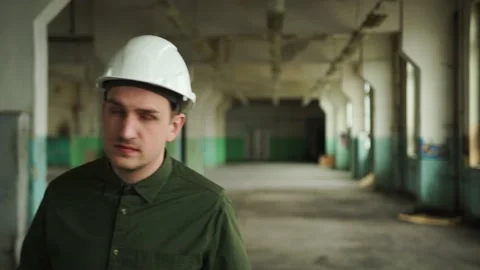 Inspector in helmet walks along the corridor of an old building, looks around Stock Footage 152679951