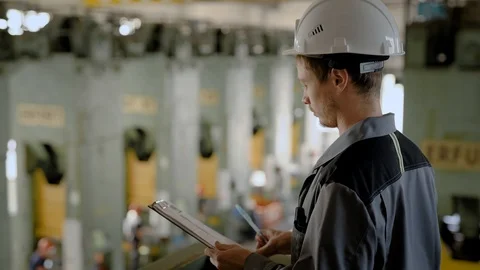 Inspector looking over the plant workers during work, writing down results. Stock Footage 94998959