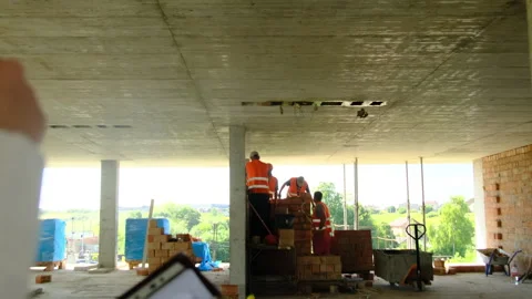 Inspector points at construction workers performing tasks Stock Footage 317612313