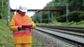 Inspector of railway traffic makes notes in his documents HD Footage