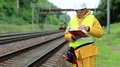 Inspector of railway traffic. Railway worker in yellow uniform with documents HD Footage