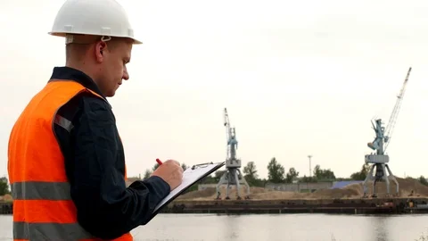 The inspector records the problems identified in the operation of port cranes in Stock Footage 95190043
