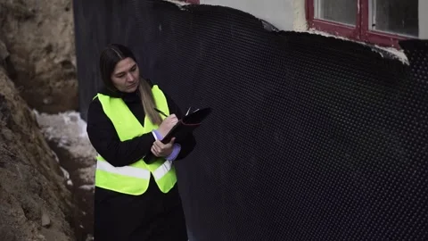 Inspector Reviews Construction Site Insulation with Checklist Stock Footage 337701814