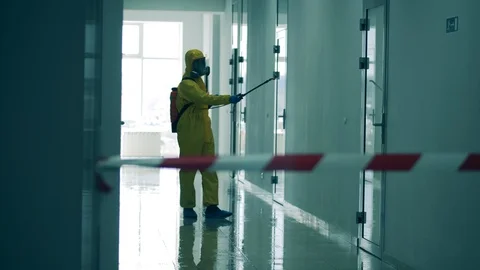 Inspector in a splash suit is sanitizing a hallway. Coronavirus pandemic, virus Video stock 129515327