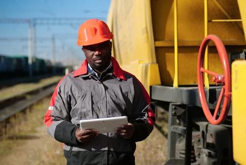 Inspector of wagons at freight train station with tablet computer 写真素材
