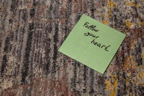 Inspirational message on a sticky note placed on a textured carpet Stock Photos