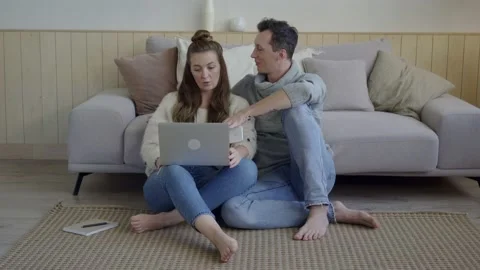 Inspired couple discussing project plans. Young freelancers with gadget and Stock Footage 139573453