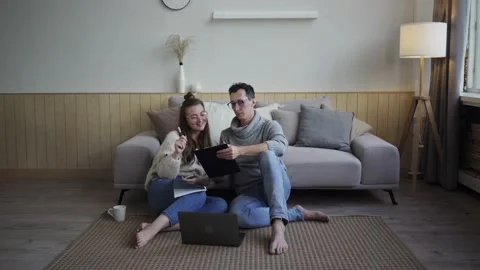 Inspired couple discussing project plans. Young freelancers with gadget and Stock Footage 139573512
