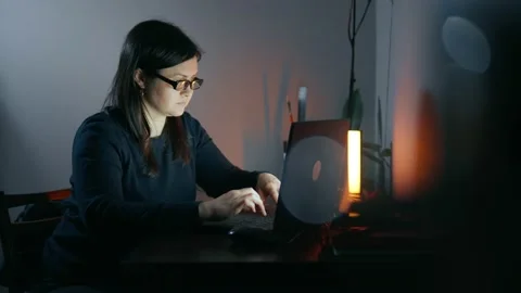 Inspired lady sits focused on work at laptop in the evening alone. Stock Footage 238951346
