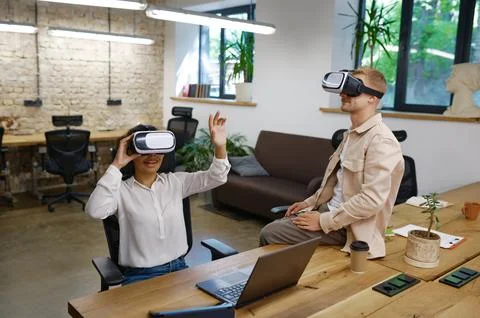 Inspired man and woman coworker wearing vr goggles in office Stock Photos