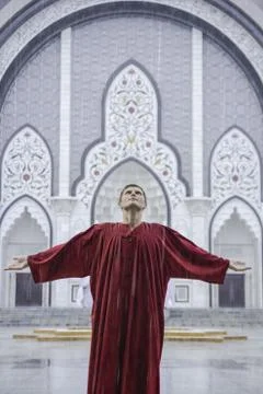 Inspired man in red looking up to the sky with arms outstretched sides Stock Photos