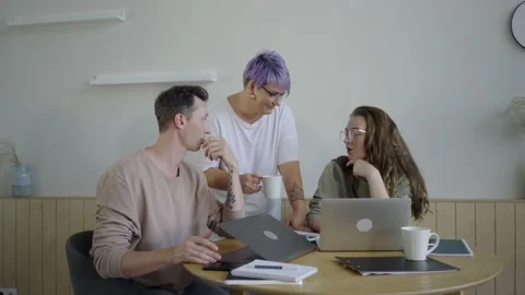 Inspired modern workers with gadgets at table. Inspired couple with manager Stock Footage 139593624