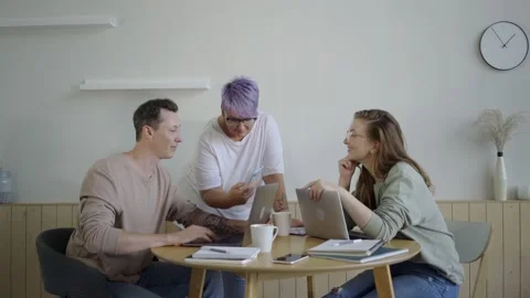Inspired modern workers with gadgets at table. Inspired couple with manager Stock Footage 139593635