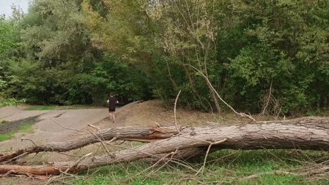 Inspired by nature, a man runs through the green forest, filling his body with Stock Footage 303562274