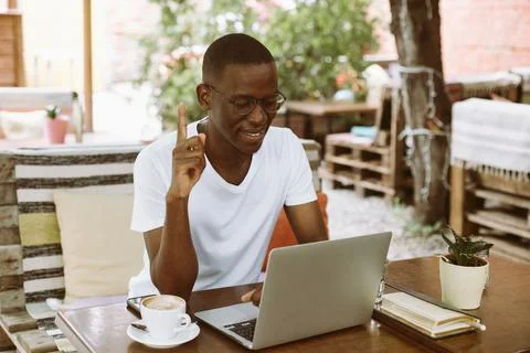 Inspired, smiling multicultural, mix raced man indexing and pointing up, getting Stock Photos