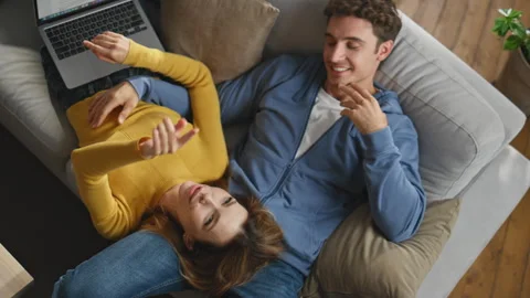 Inspired sweethearts planning future resting at grey sofa closeup. Loving pair Stock-Footage 264698934