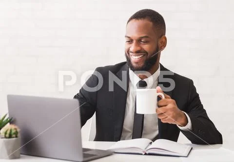 Inspired Young Entrepreneur Drinking Tea While Working In Office