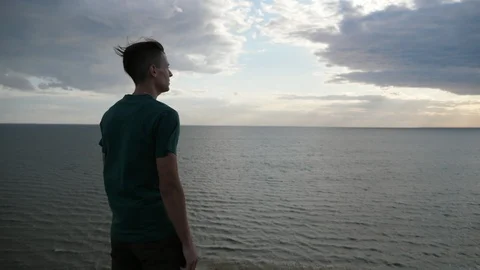 Inspired young guy standing and looking at the Black Sea waters in slo-mo Stock Footage 113113841