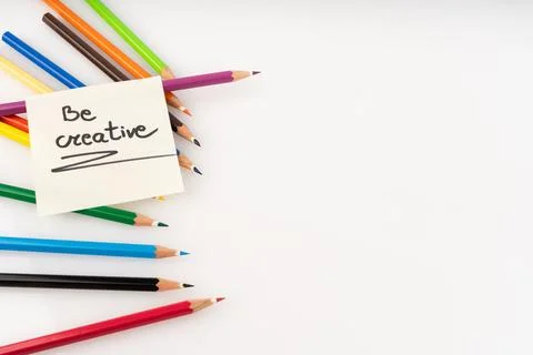 Inspiring 'Be Creative' note amidst vibrant colored pencils on a clean whit.. Stock Photos