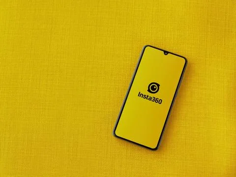 Insta360 app launch screen on smartphone on yellow fabric background. Stock Photos